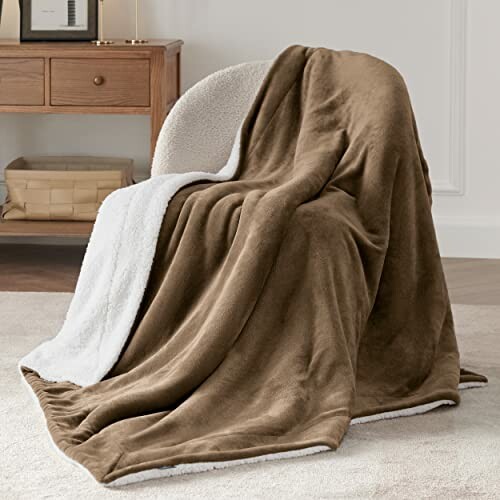 Brown sherpa blanket draped over a chair in a cozy room.