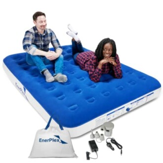 Two people sitting on an EnerPlex air mattress with accessories.