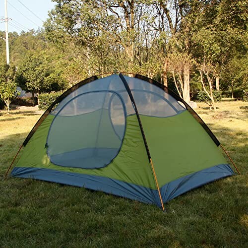 Green camping tent set up in a grassy forest area.