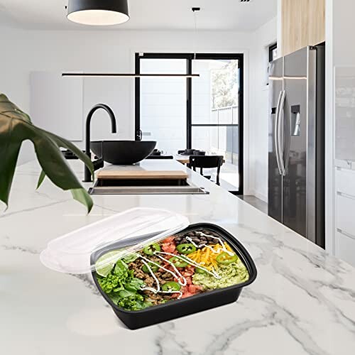 Salad container on kitchen counter with modern appliances