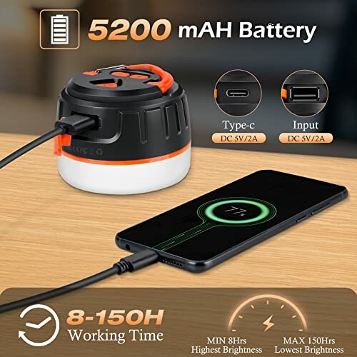 Portable camping lantern with 5200mAh battery and Type-C input charging a smartphone on a table.