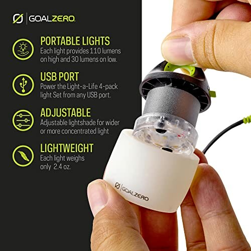 Hand holding a small portable light with USB port, adjustable shade, and lightweight design.