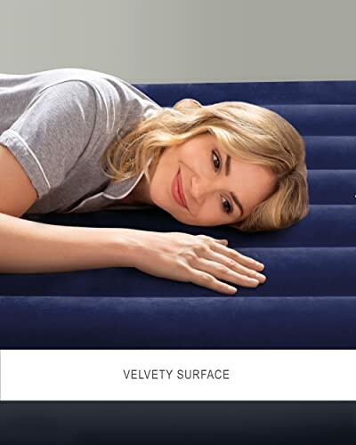 Woman resting on a velvety air mattress surface.